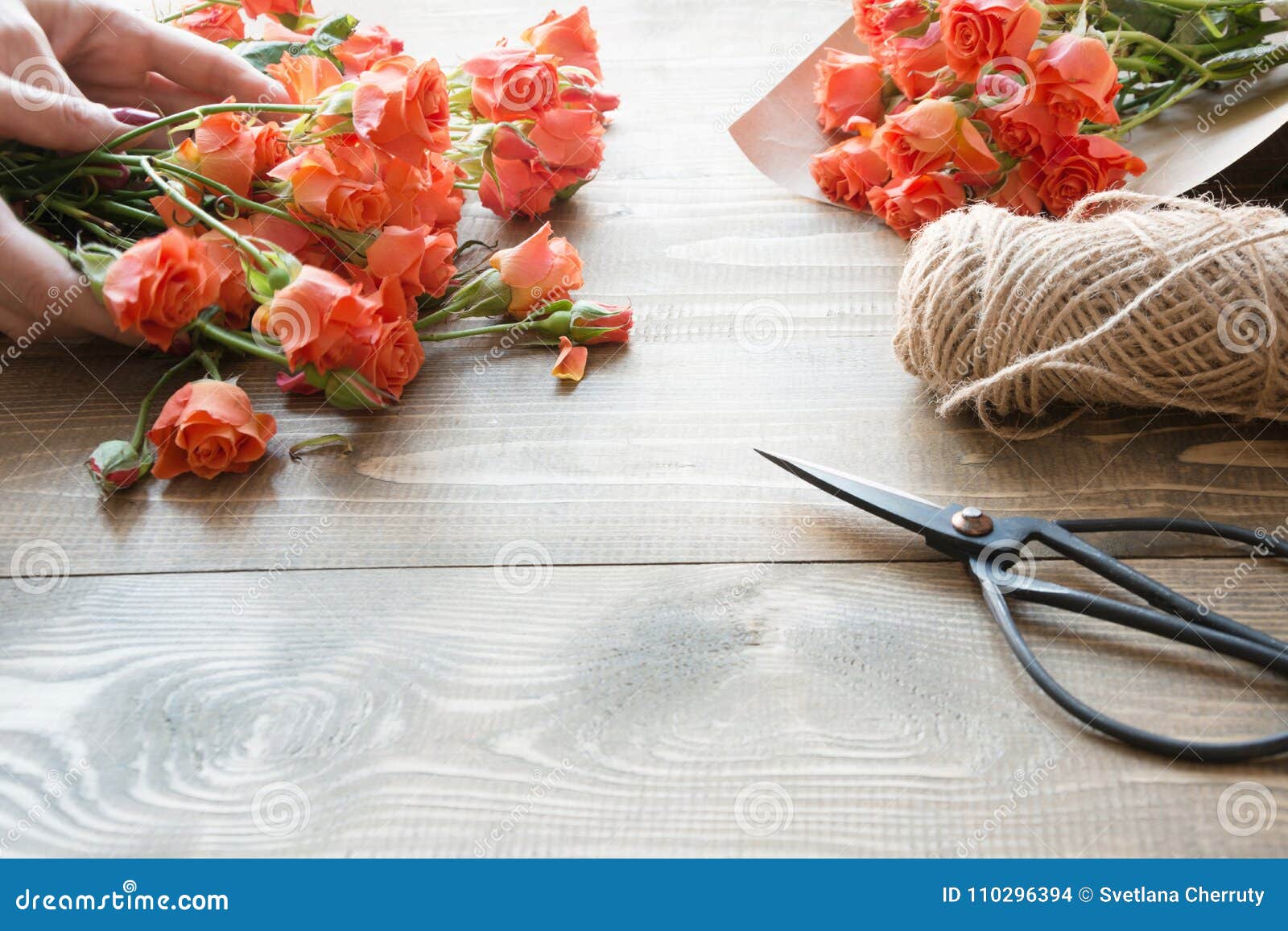 working table florista.preparation a bouquet of orange shrub roses.