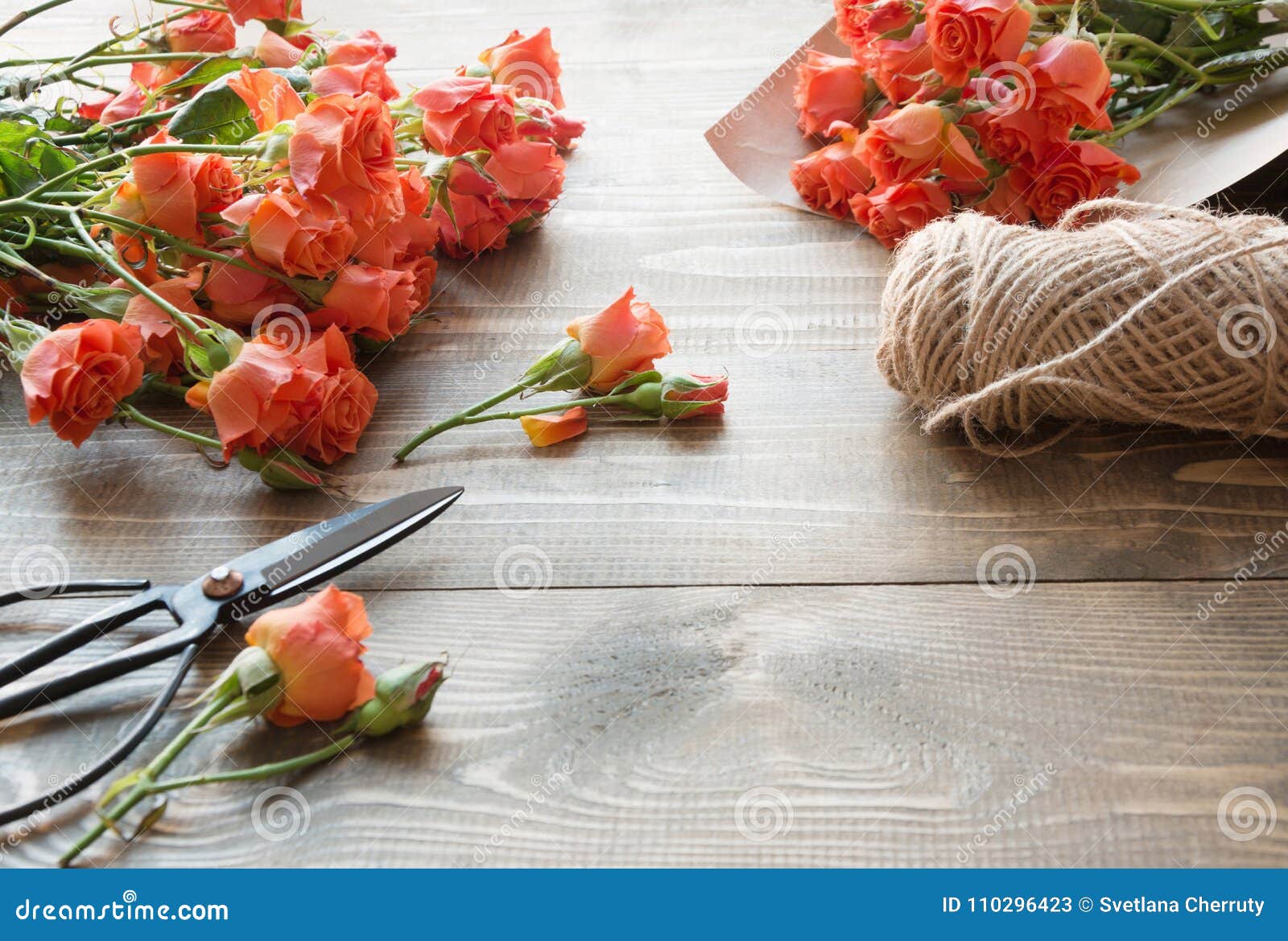 working table florista.preparation a bouquet of orange shrub roses.