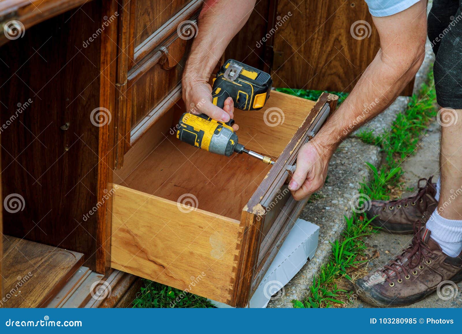 A Workman Fixing with Screwdriver in Kitchen Stock Image