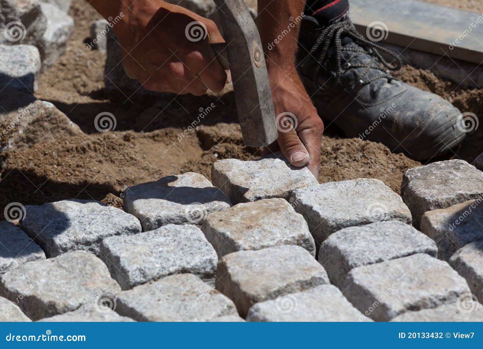 workman laying cobbles