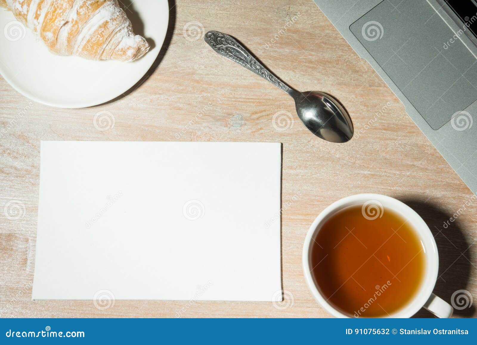 Workplace at Home with Laptop, Tea and Croissant. Top View . Stock
