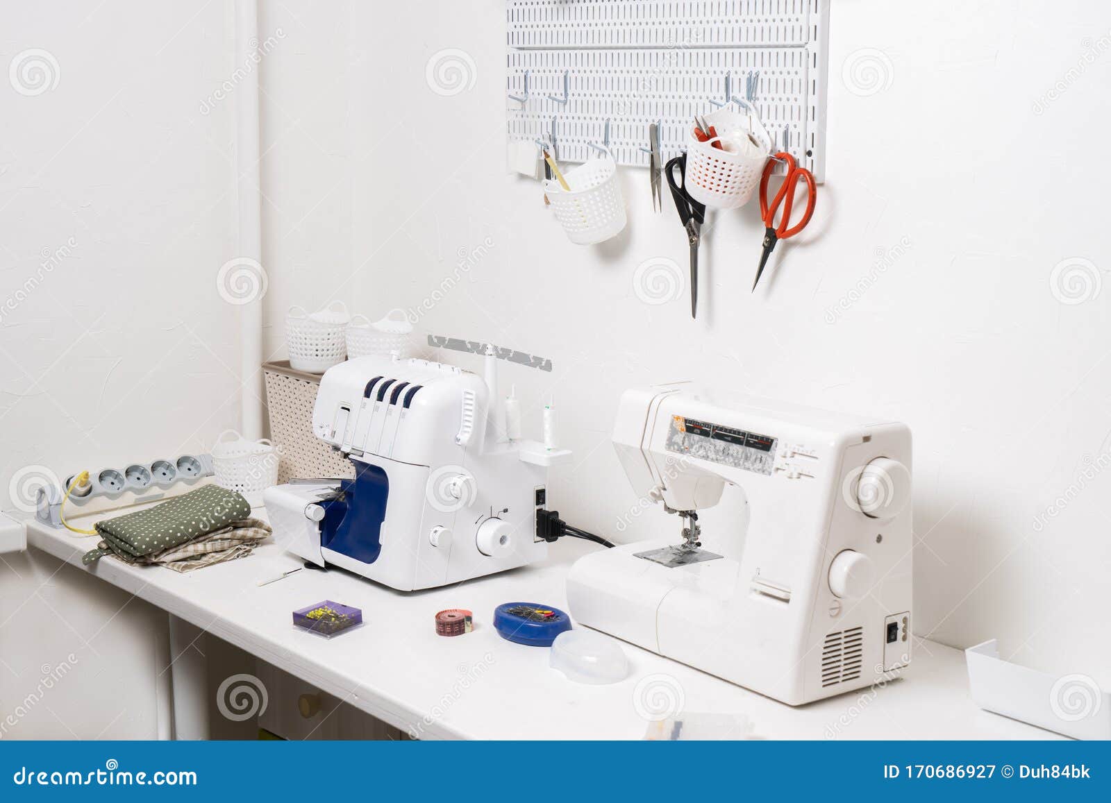 Workplace White Table with a Sewing Machine and an Overlock for Sewing