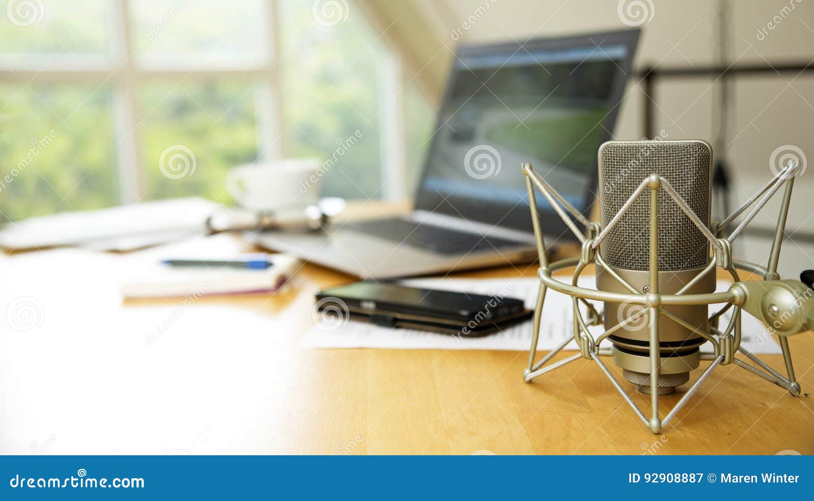 workspace for journalism with condenser microphone, laptop, cell