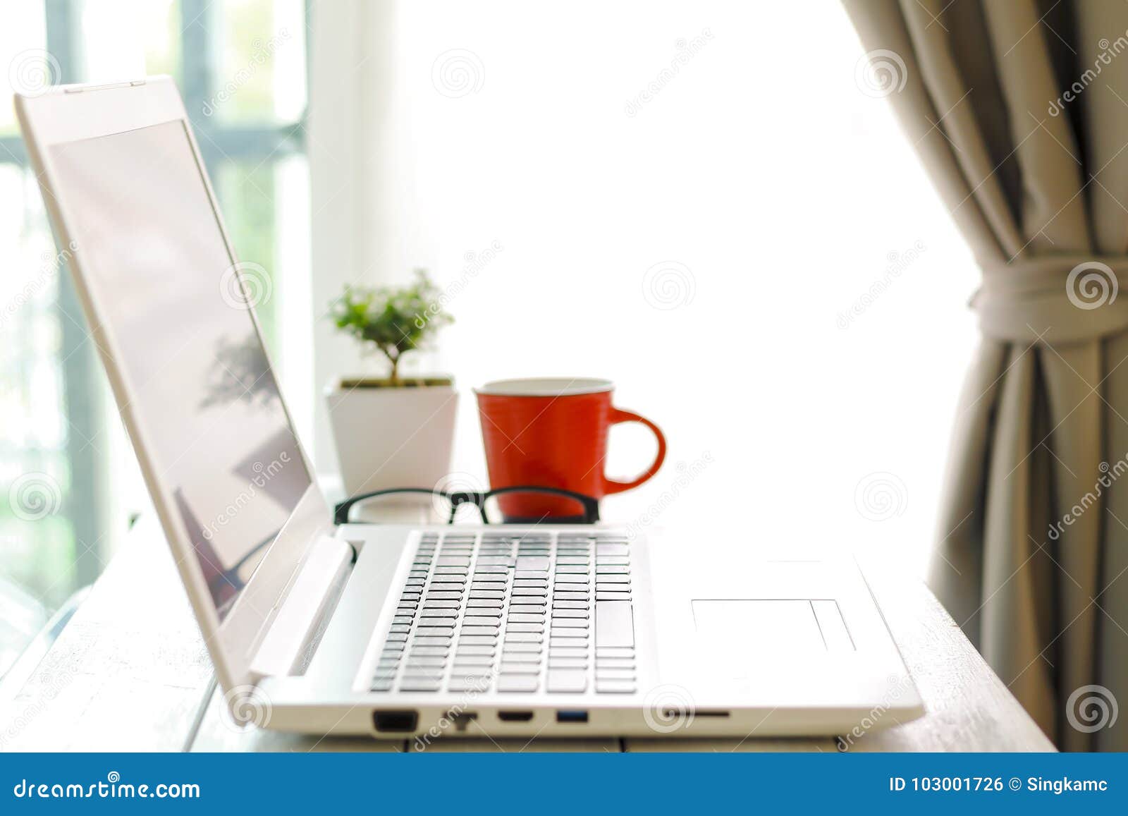 workspace with modern laptop at sunrise