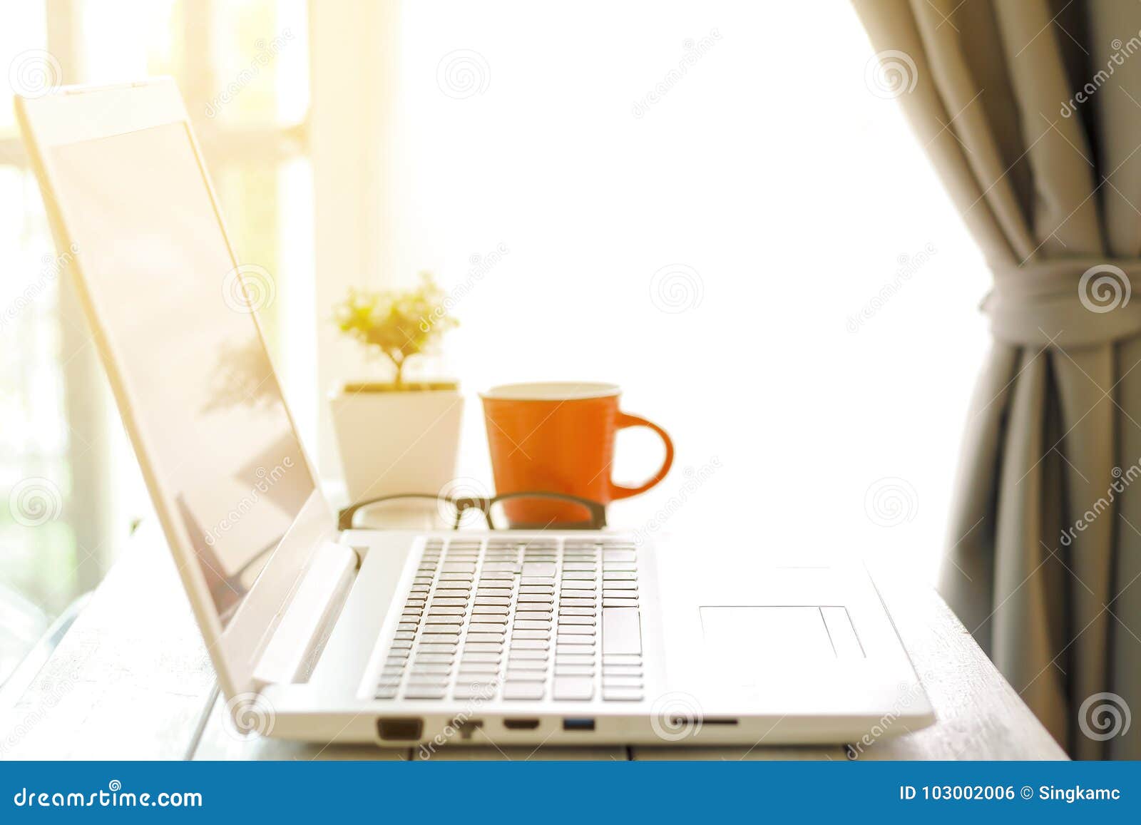 workspace with modern laptop at sunrise