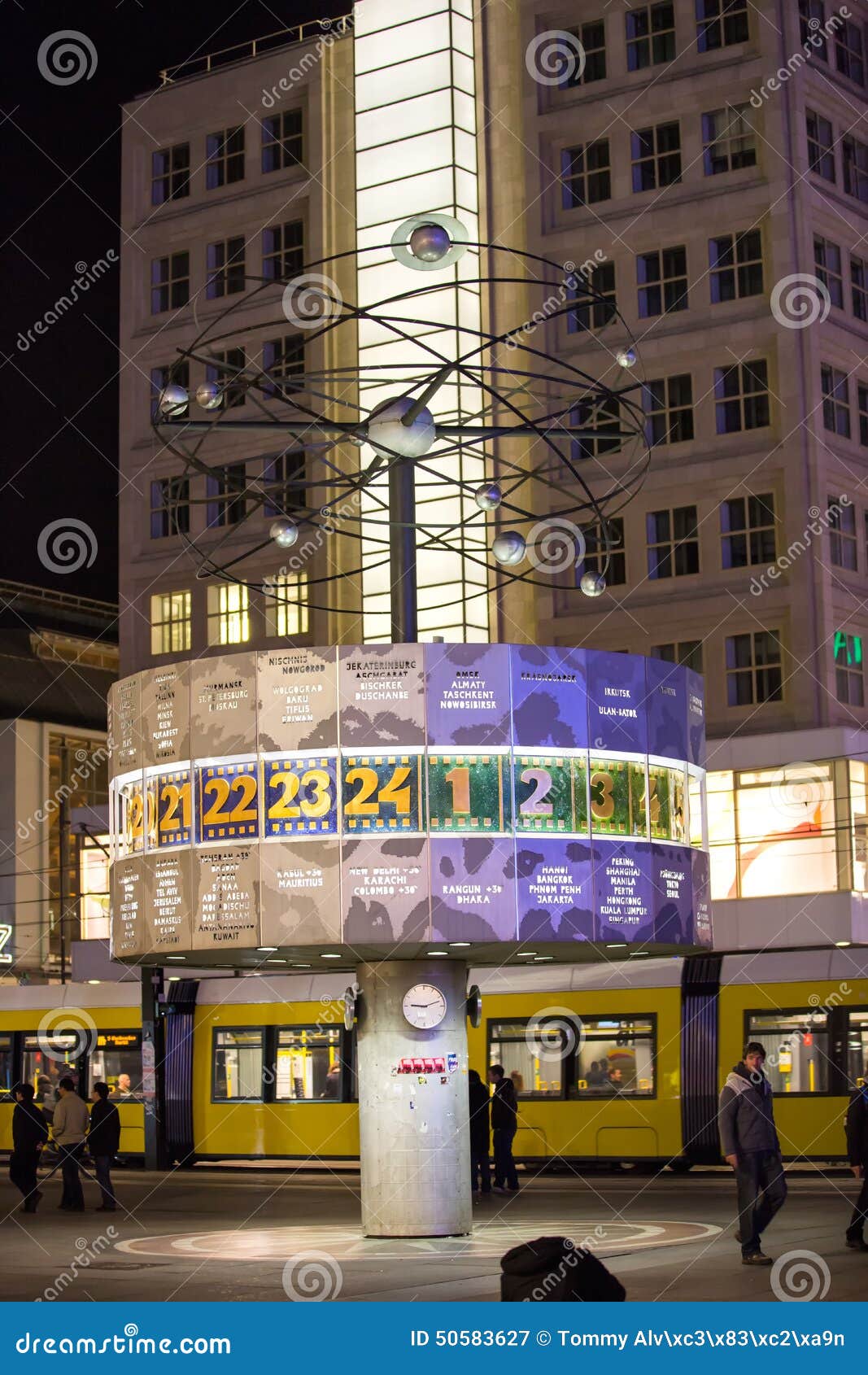 World clock at Alexanderplatz late evening with a tram behind.