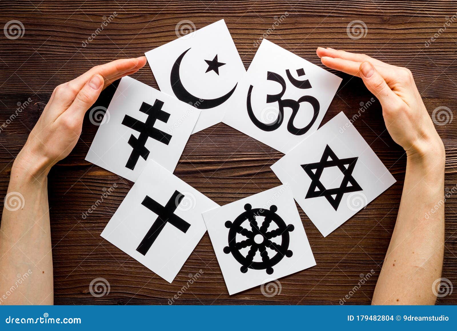 world religions concept. hands hugs christianity, catholicism, buddhism, judaism, islam s on wooden background top