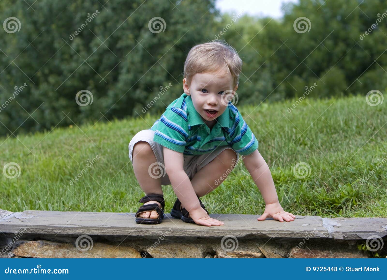 Worried boy on wall. Worried young boy climbing down rock wall