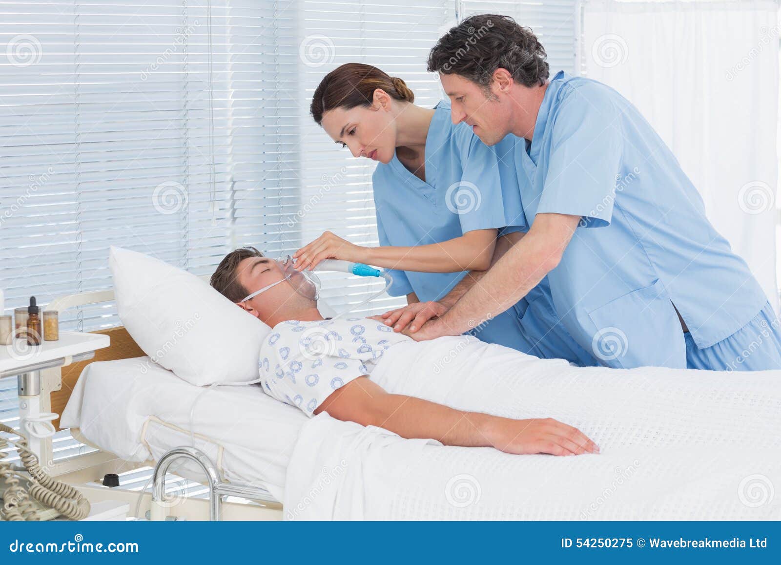 Worried Doctors Doing Heart Massage And Holding Oxygen Mask Stock Image