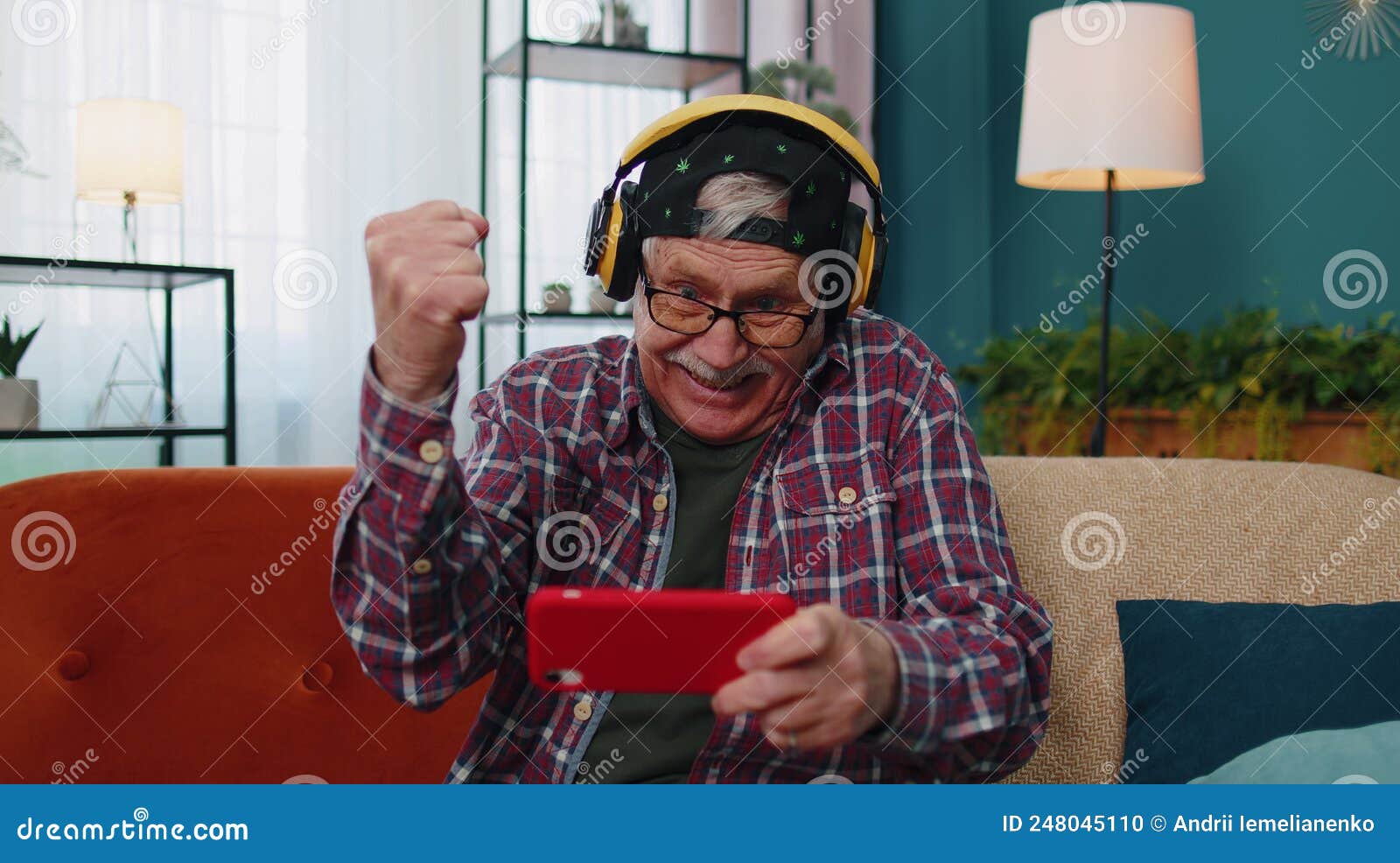 Worried Funny Senior Old Grandfather Man Playing Shooter Online Video Games on Mobile Phone at Home Stock Photo