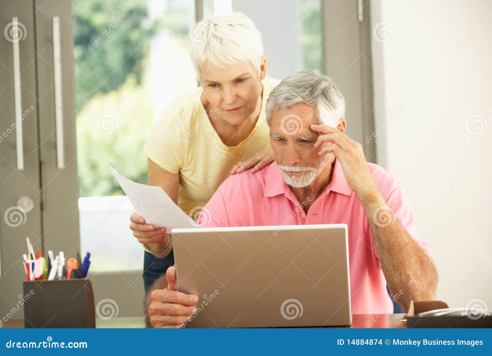 worried senior couple using laptop at home