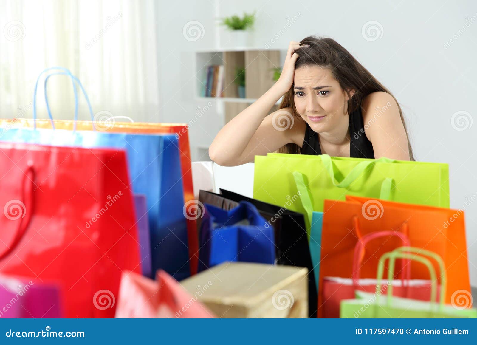 worried shopaholic woman after multiple purchases