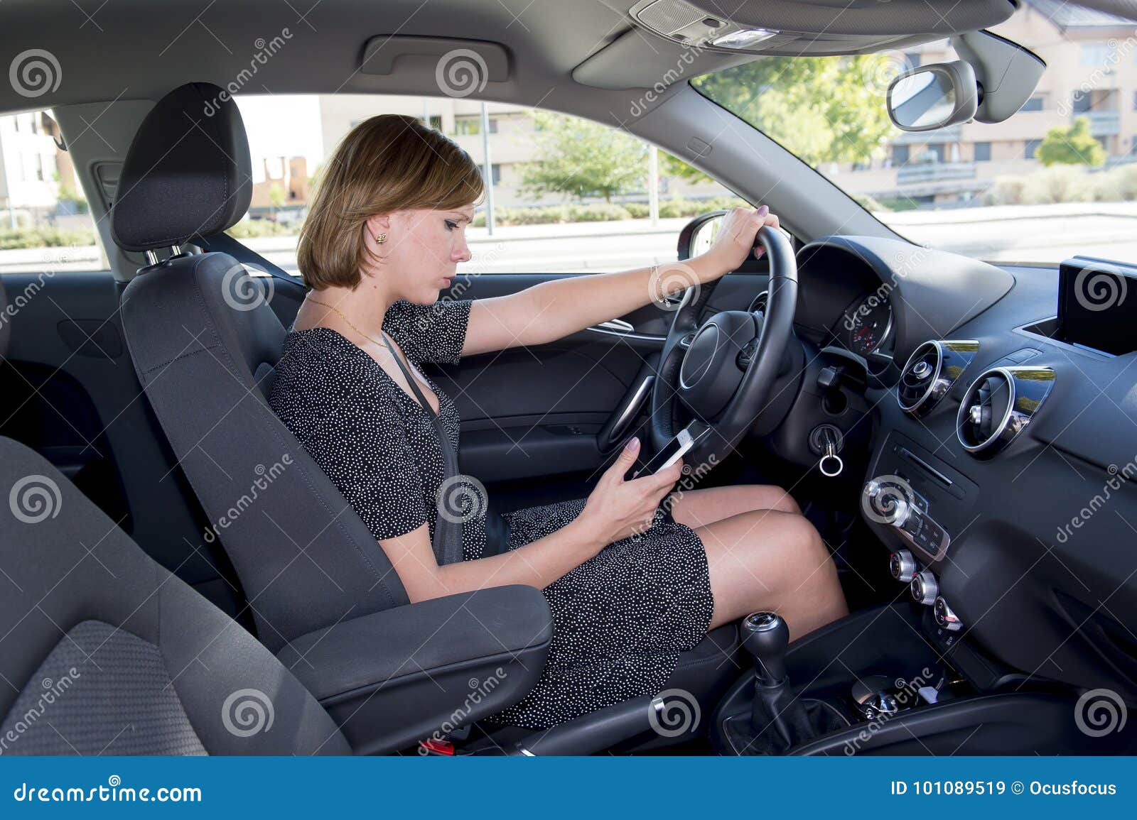 Worried And Stressed Woman Driving Car While Texting On Mobile Phone