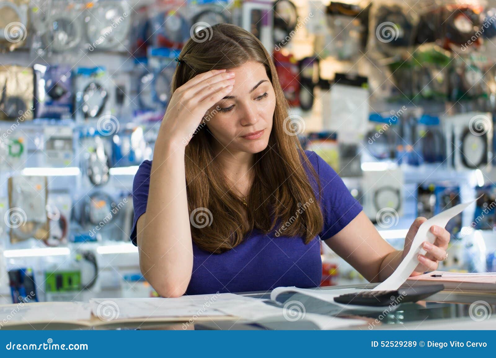 Worried Woman Checking Bills and Invoices in Computer Shop Stock Image