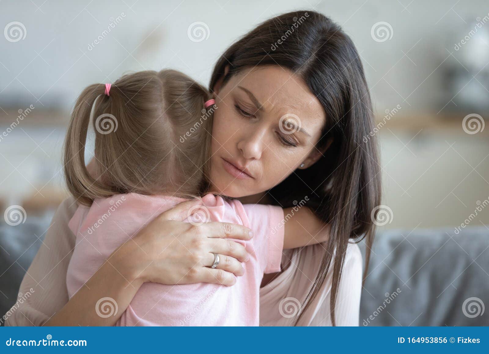 worried young foster mother comforting embracing adopted child daughter