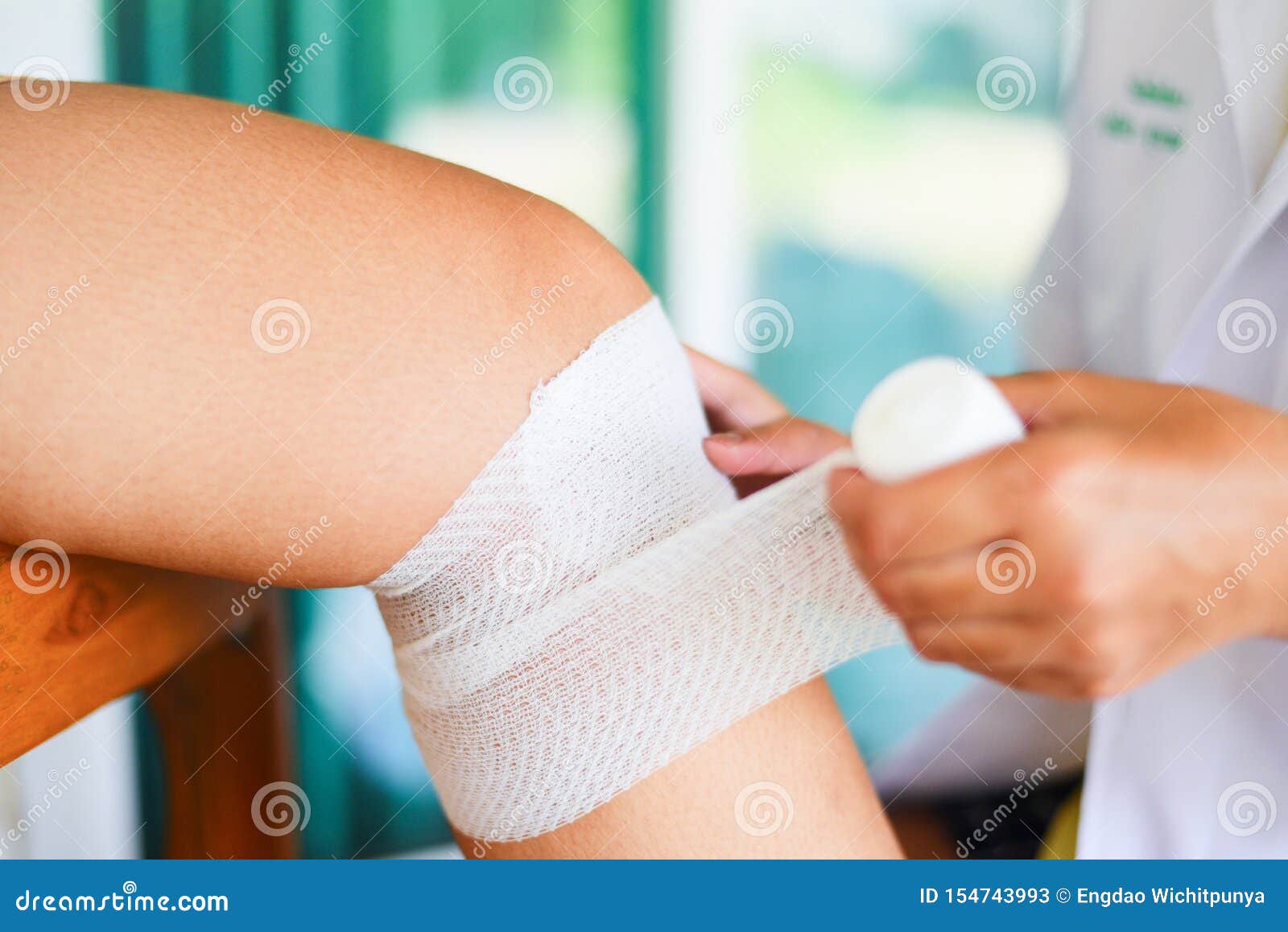 wound bandaging an injured knee from fall by nurse - first aid leg injury health care and medicine concept