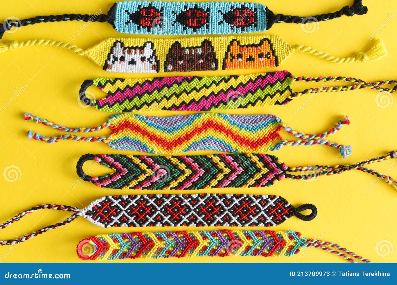 Female hand holding many woven multi-colored DIY friendship bracelets  handmade of embroidery thread with knots on white background Stock Photo -  Alamy