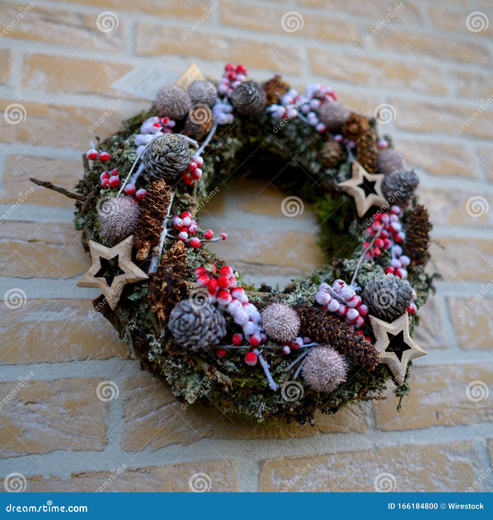 Wreath with Beautiful Christmas Decorations Hanged on the Cobblestone ...