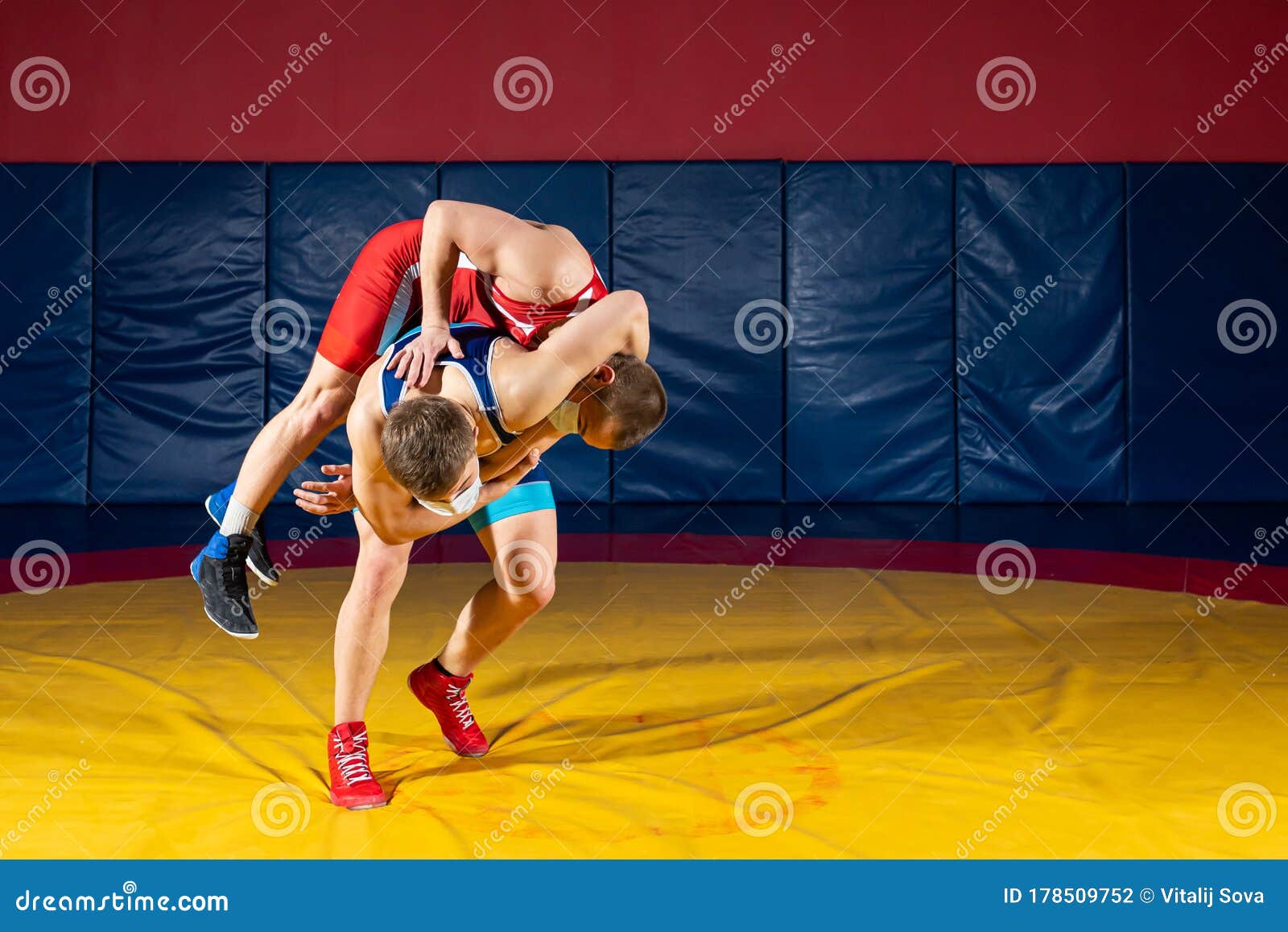 Two men in sports wrestling tights and wrestling during a traditional  Greco-Roman wrestling in fight on a wrestling mat. Wrestler throws his  opponent's chest through Photos