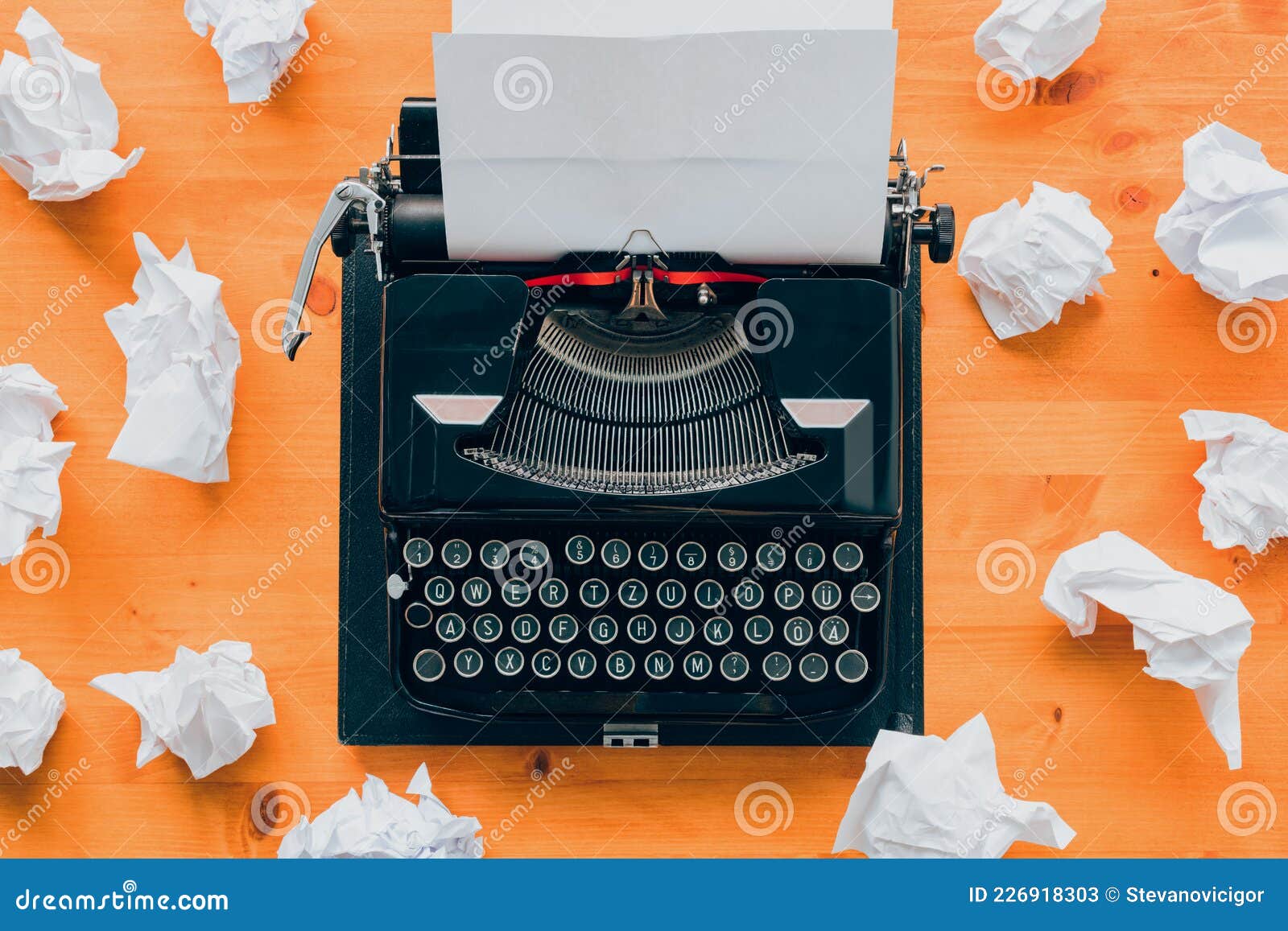 writer`s block concept, top view of vintage typewriter machine and crumpled paper
