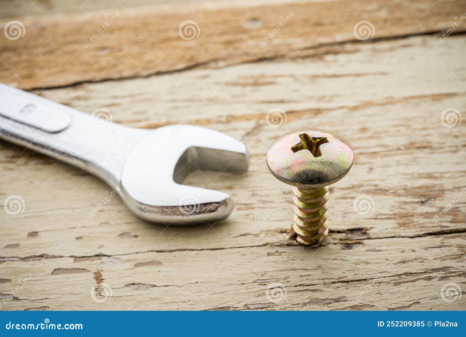 wrong tool for this job. screw and open end wrench on old wooden background. recruitment, hr human resources management