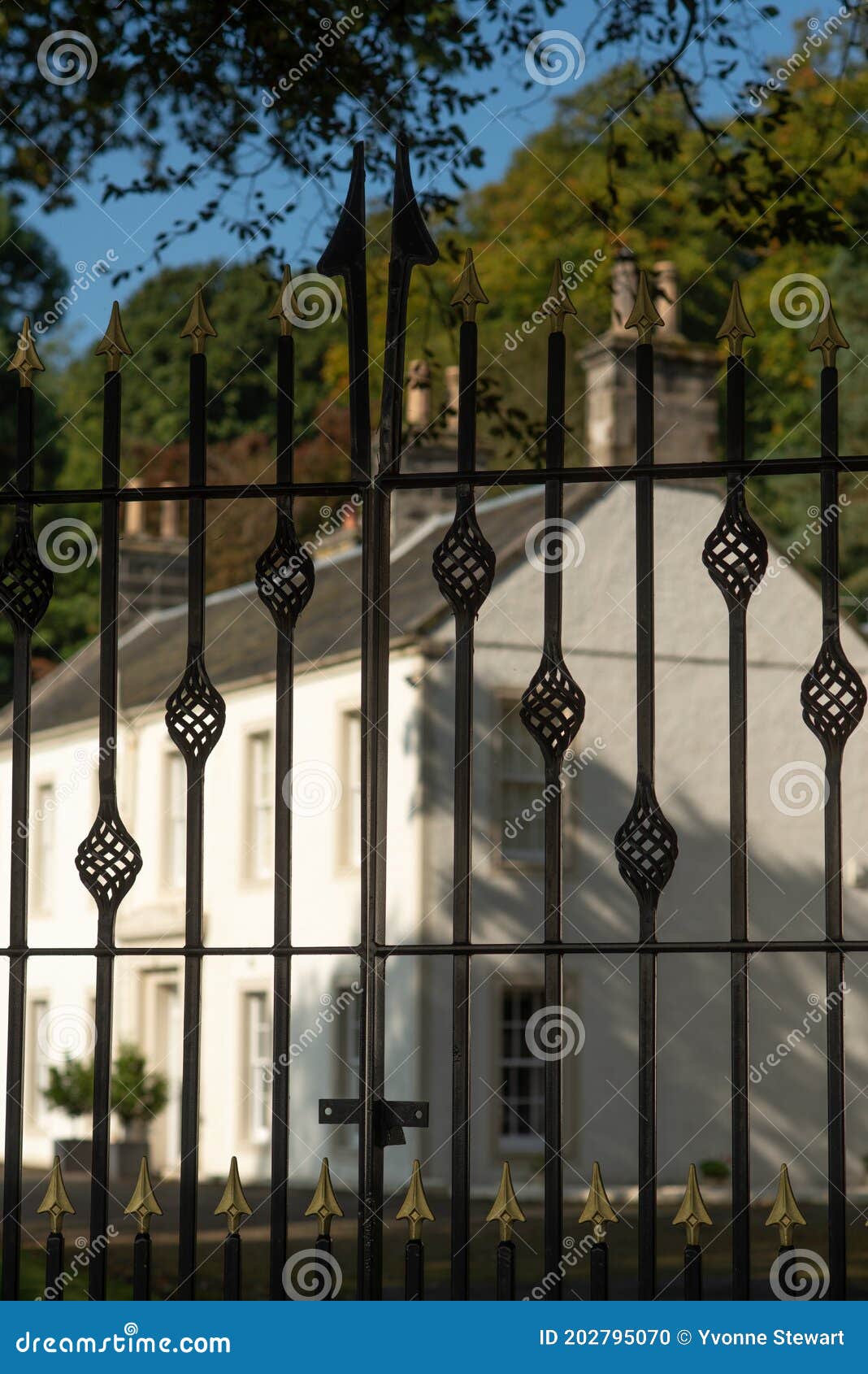 Wrought Iron Gate with an Elegant Mansion House in the Background Stock ...