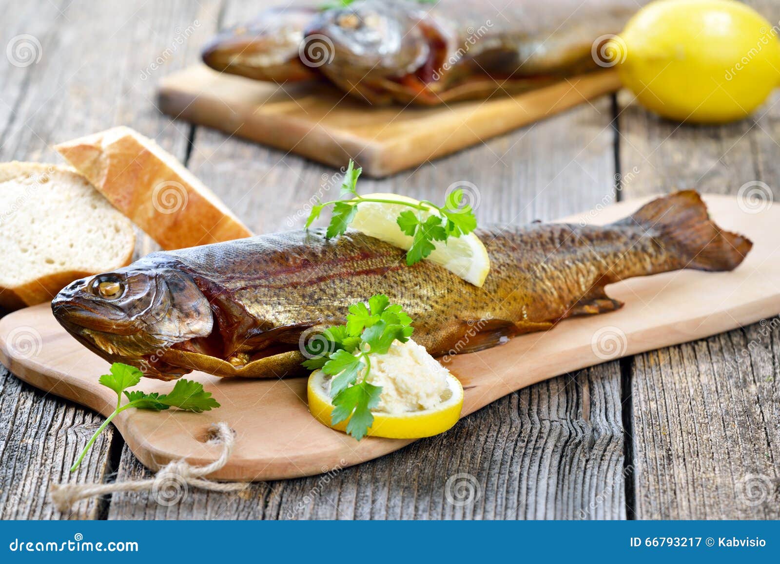 Wędzonego węgorza. Uwędzony tęcza pstrąg słuzyć na drewnianej tnącej desce z horseradish, pietruszką, cytryną i baguette,