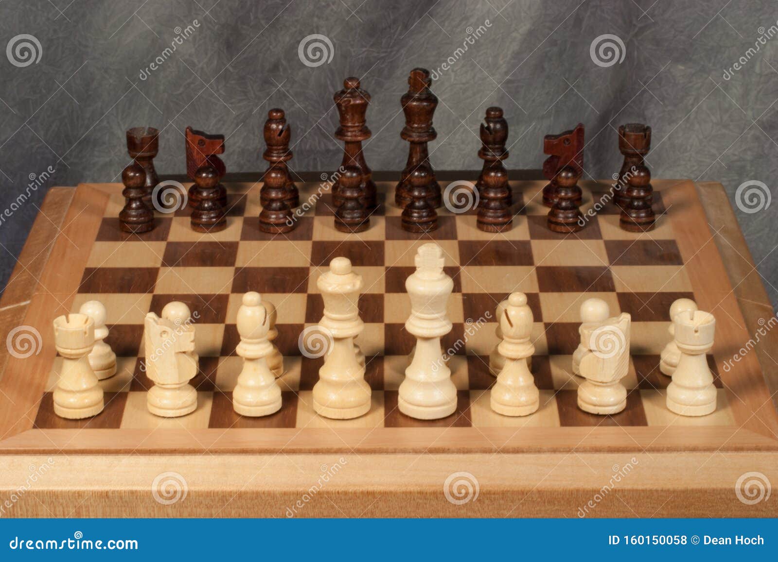 Vista superior do antigo tabuleiro de xadrez com um conjunto de peças de  madeira pretas e brancas em uma posição caótica