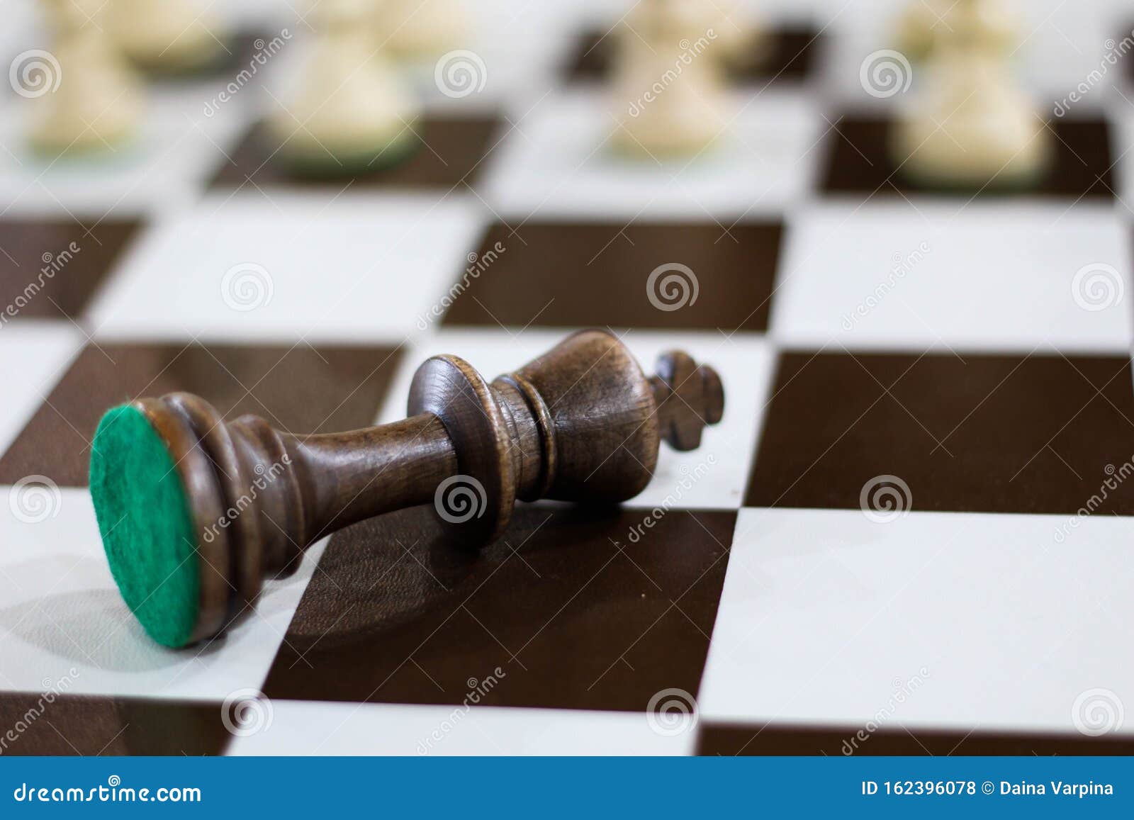 Xeque-mate. jogo de xadrez. rei do xadrez deitado no tabuleiro de xadrez e  a figura da rainha acima dela. figuras de xadrez no tabuleiro