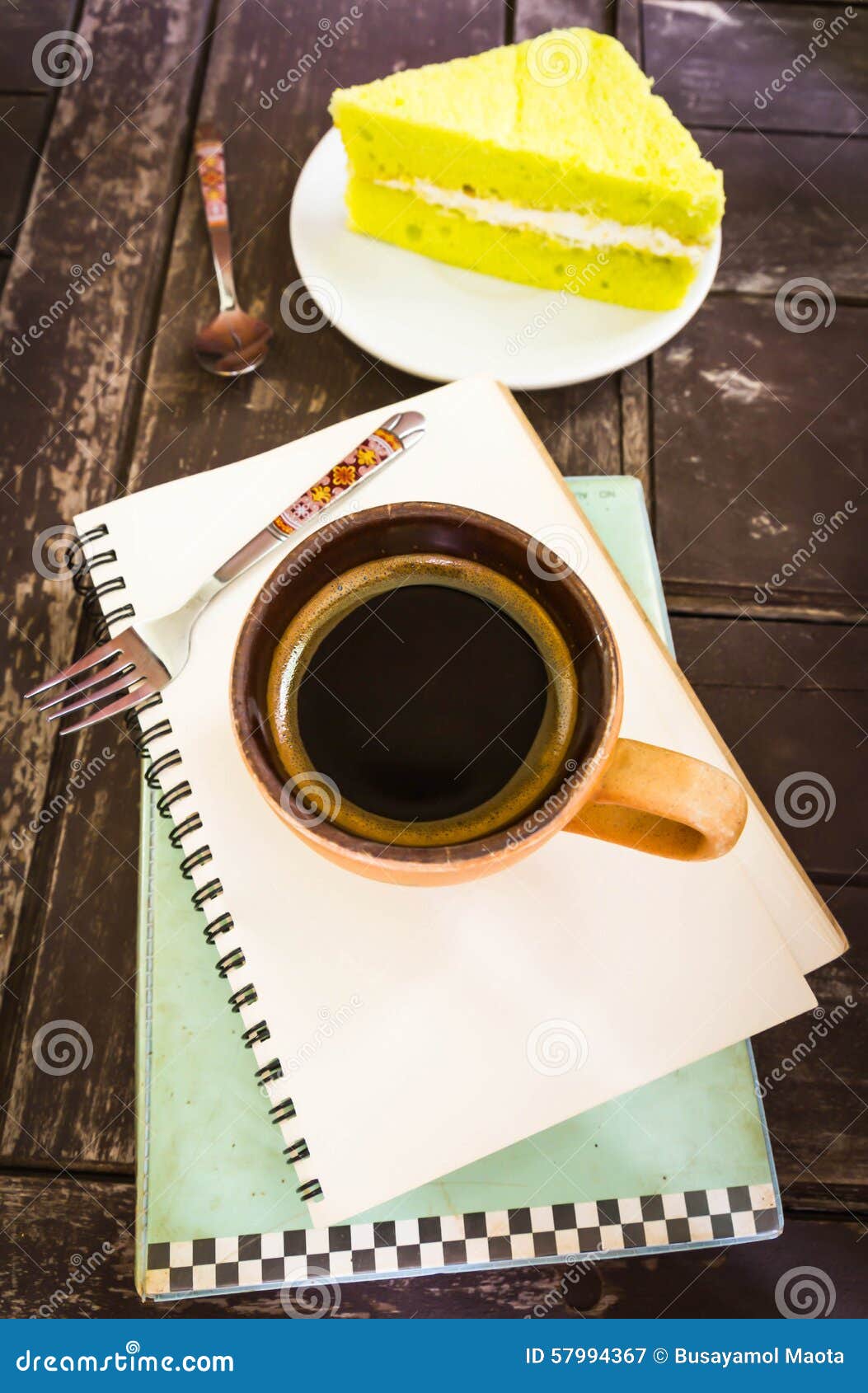 Xícara de café e papel de nota no vint de madeira do fundo da textura. A xícara de café com colher e o papel de nota na cor de madeira do vintage do fundo da textura tonificam