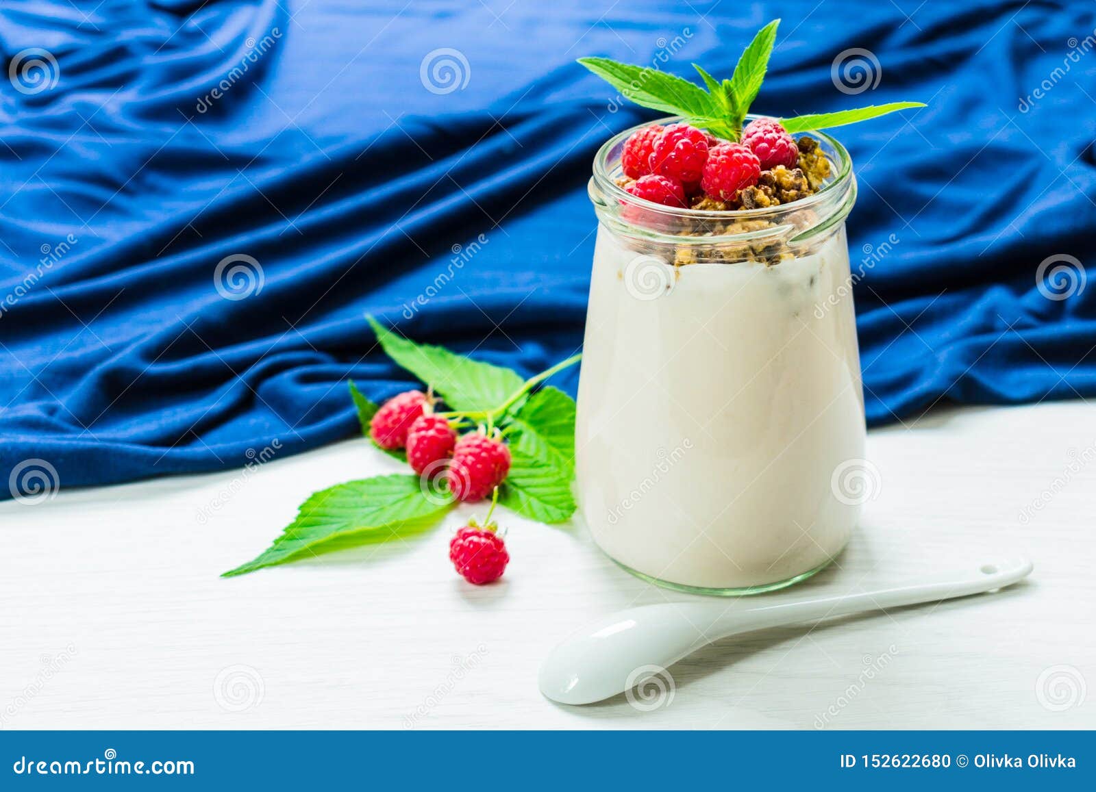 Yaourt Avec Des Baies De Framboise Et Muesli, Décoré Des Feuilles En Bon  état, Dans Un Petit Pot En Verre Sur Une Table Blanche a Photo stock -  Image du normal, croustillant