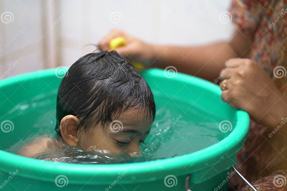 2 year old Indian Baby Boy Enjoying A Bath In A Green Tub Stock Image 2-year-old-indian-baby-boy-enjoying-a-bath-in-a-green-tub-stock-image