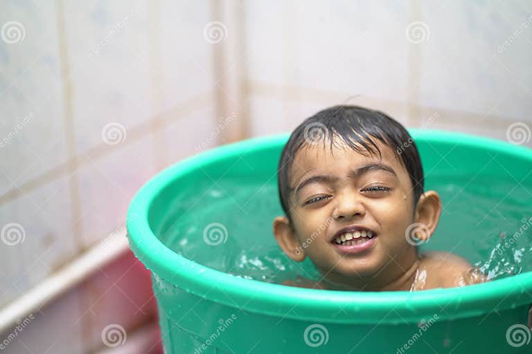 2 year old Indian Baby Boy Enjoying A Bath In A Green Tub Stock Photo 2-year-old-indian-baby-boy-enjoying-a-bath-in-a-green-tub-stock-photo