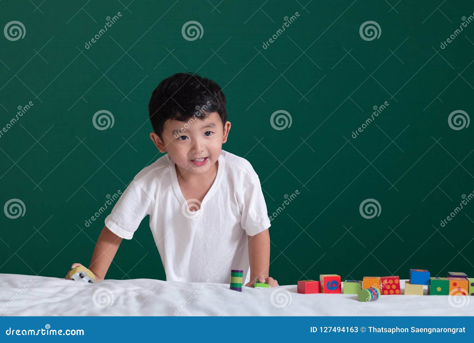 3 Years Old Asian Boy Play Toy Or Square Block Puzzle On Green C Stock
