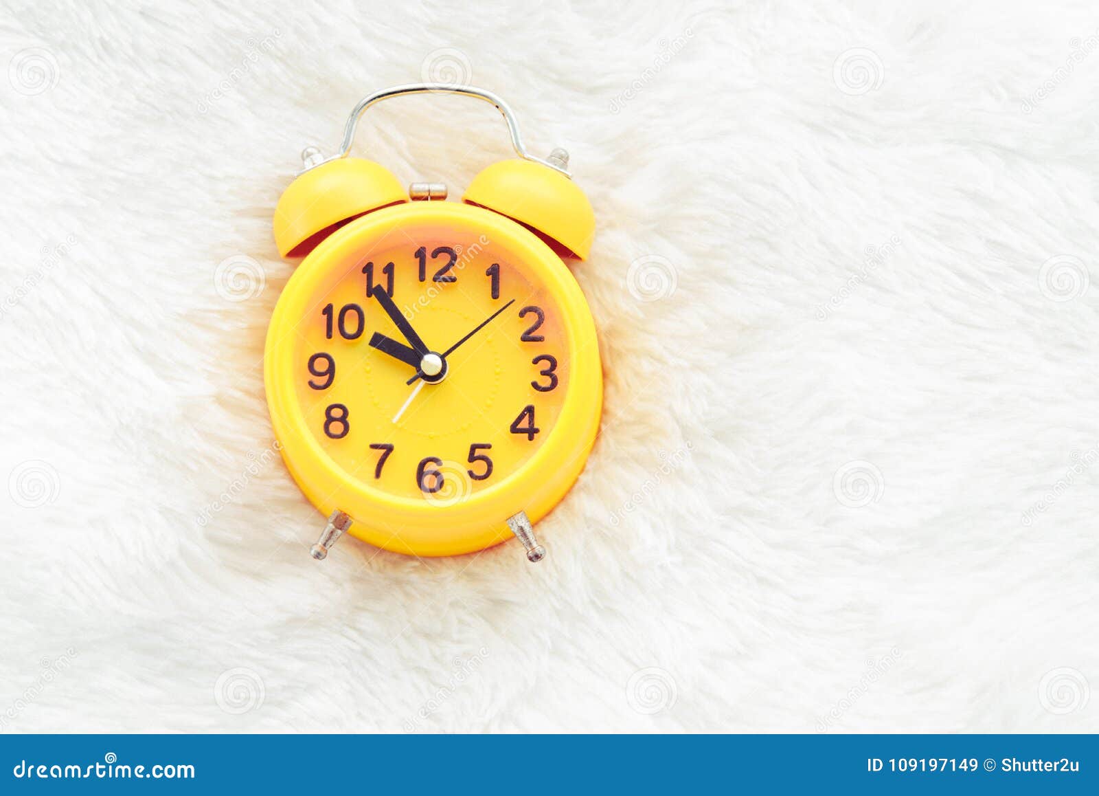 yellow alarm clock on white wool. late and lazy time concept. mo