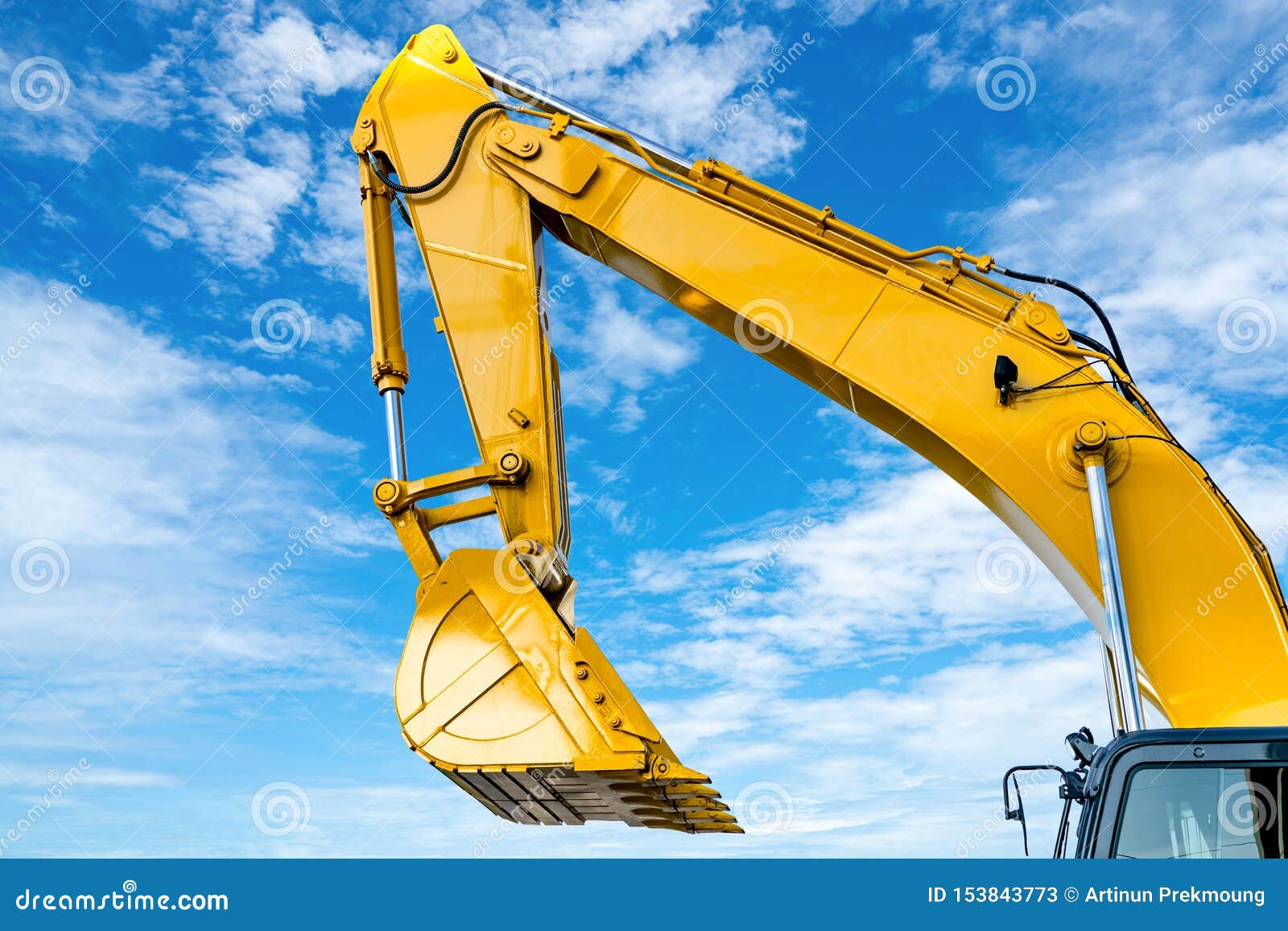 yellow backhoe with hydraulic piston arm against blue sky. heavy machine for excavation in construction site. hydraulic machinery.