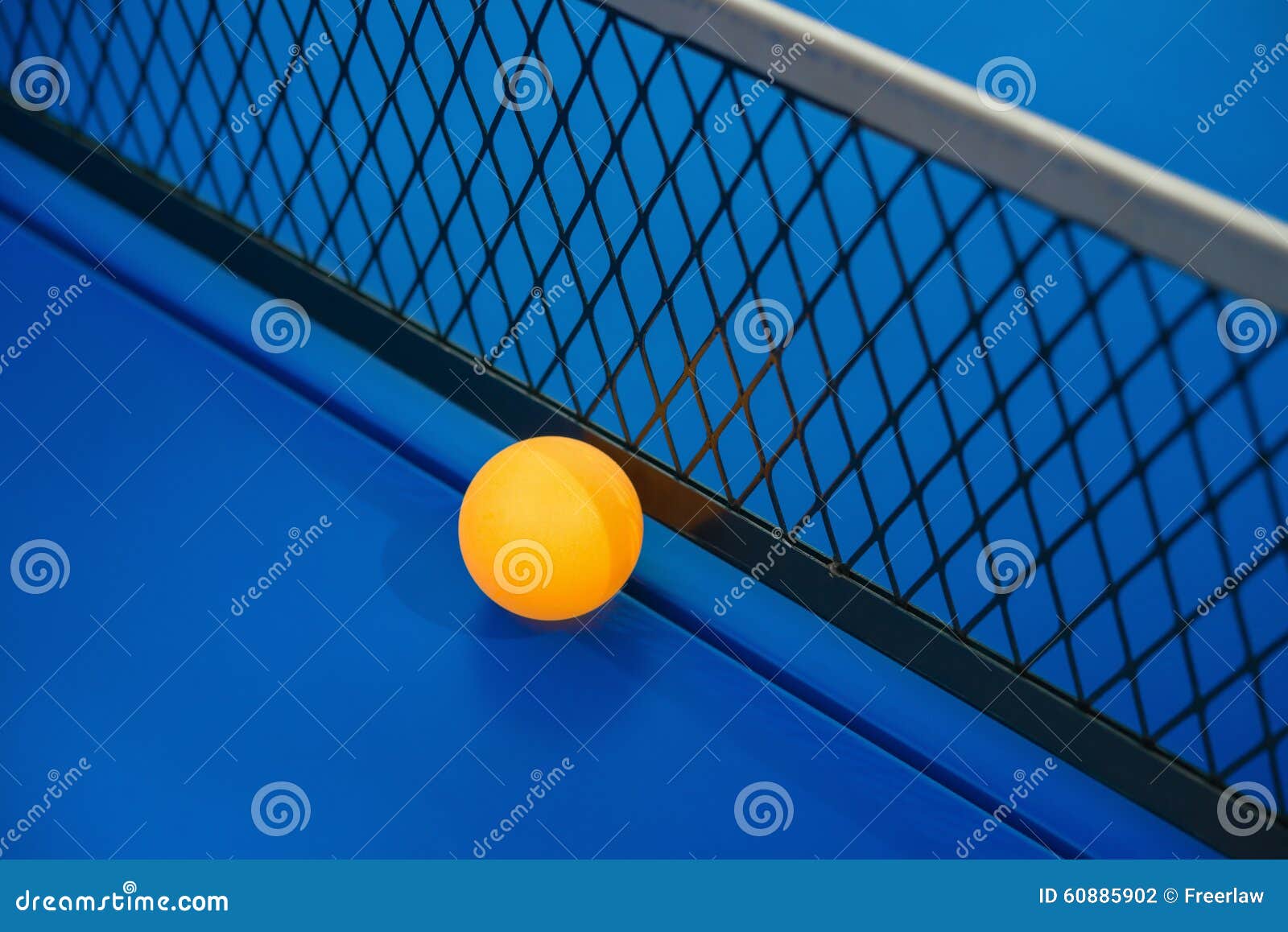 Yellow Ball Hits the Bottom of Racket on Blue Pingpong Table Stock