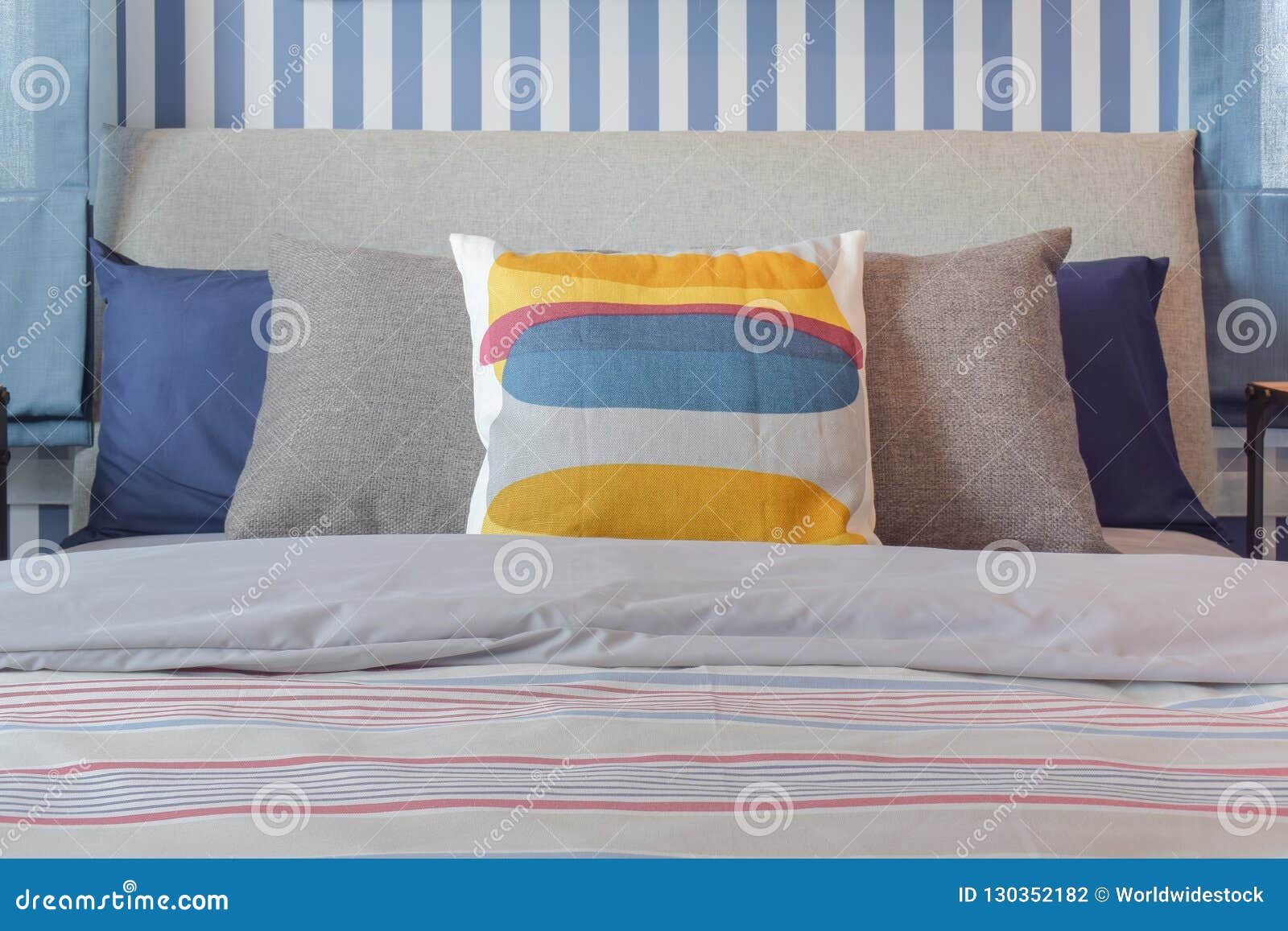 Yellow and Blue Graphic Print Pillow Setting on Stripe Bedding Stock