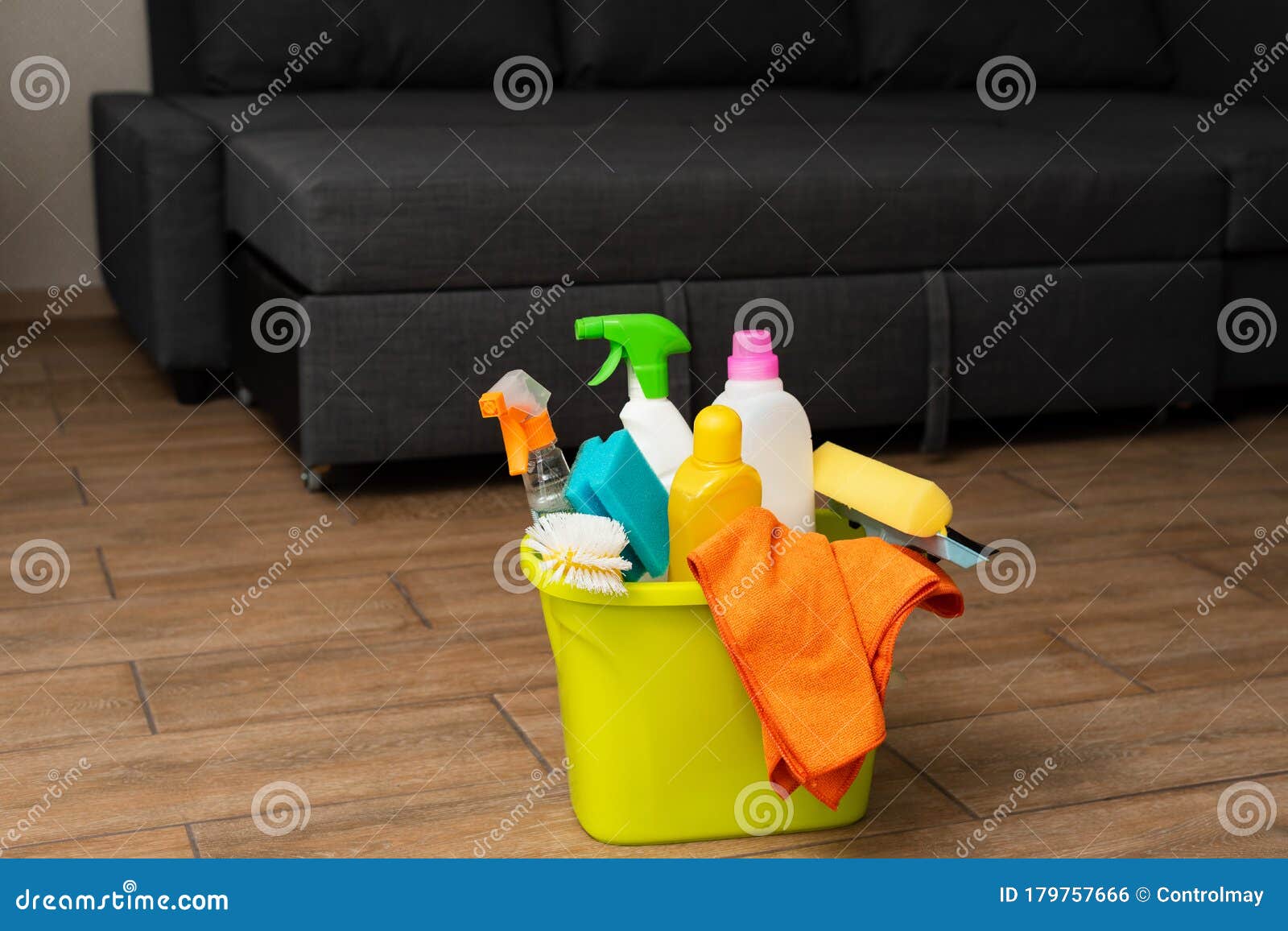 a yellow bucket with detergent in on the floor. the cleaning supplies are in bucket