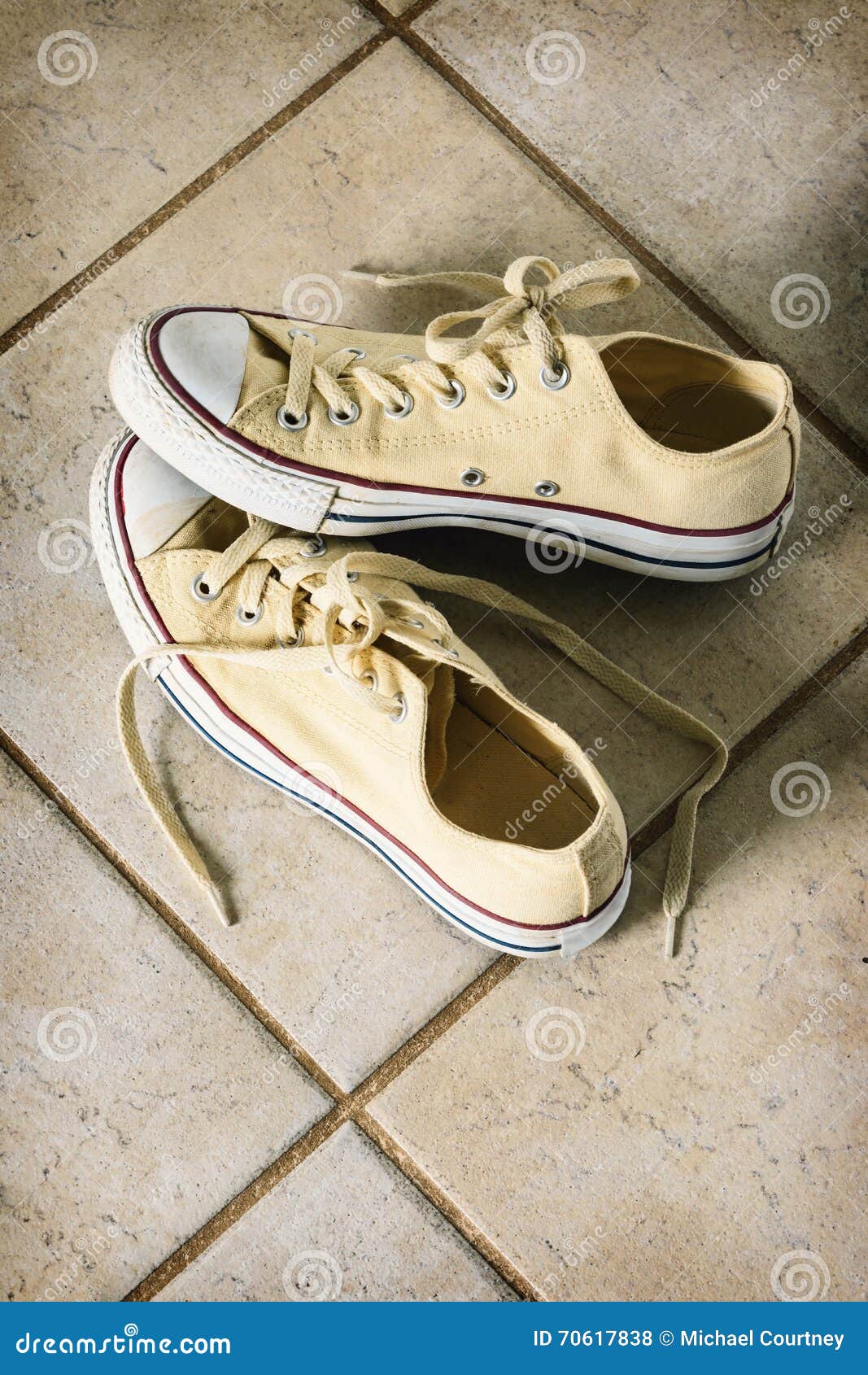 Yellow Canvas Running Shoes on a Tile Floor. Stock Photo Image of