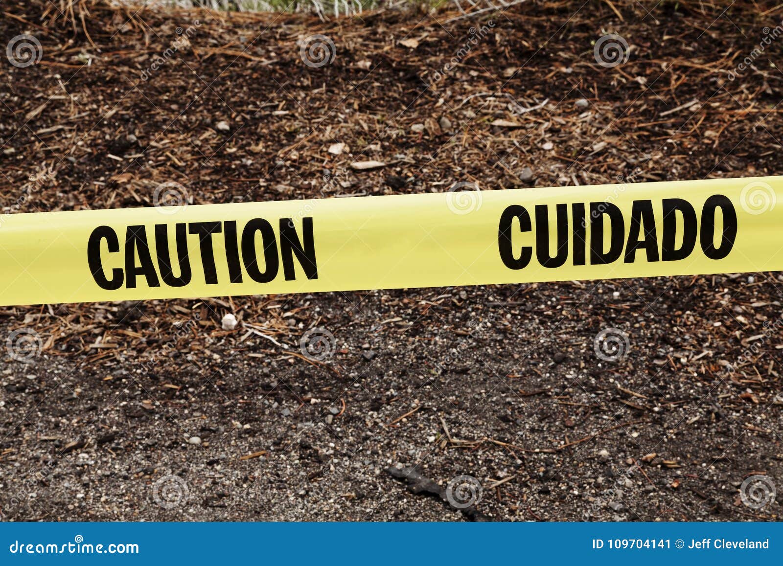 yellow caution cuidado ribbon on side of road