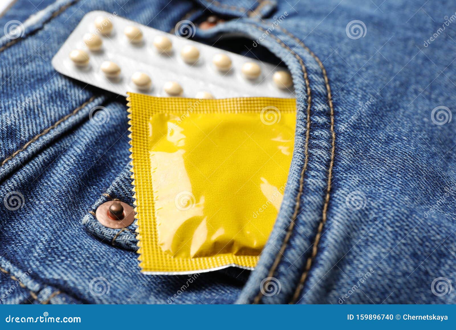 Yellow Condom And Birth Control Pills In Pocket Of Jeans Safe Sex