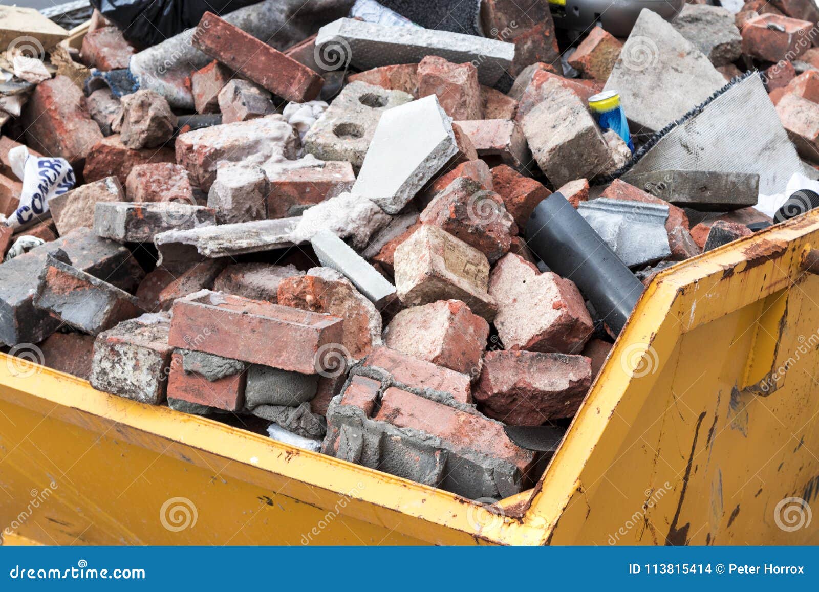 yellow dumpster skip full of masonry waste