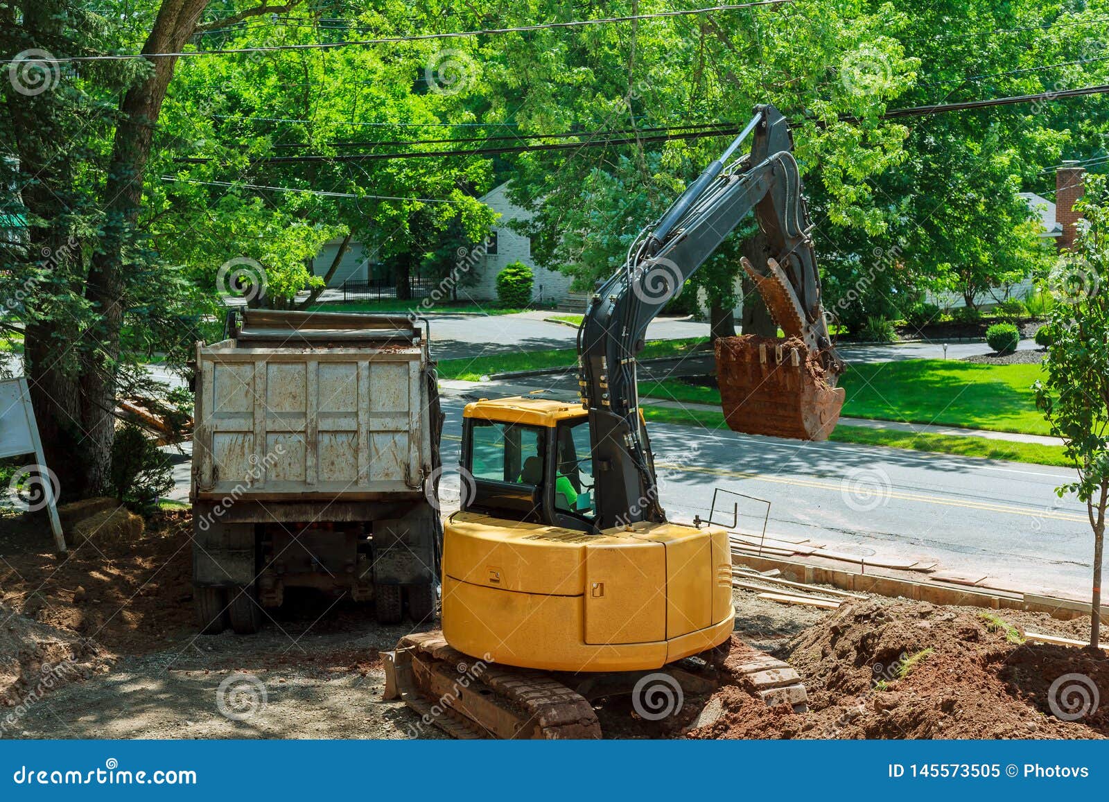 yellow heavy duty digger working in excavation pit