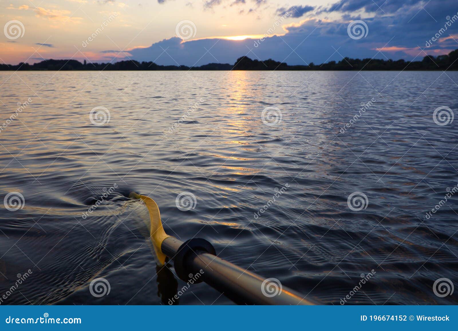 kayak paddle in a beautiful sunset on small ploner lake with dramatic clouds, plon, ploen germany