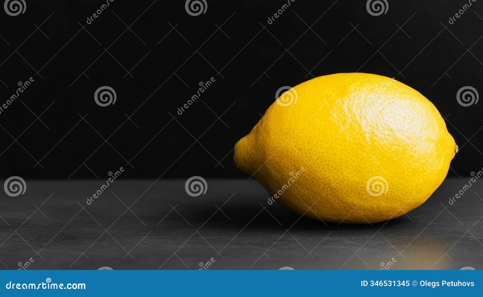 a yellow lemon, tightly framed in a close-up shot, sits against a black surfaces its mirror-like reflection perfectly replicates
