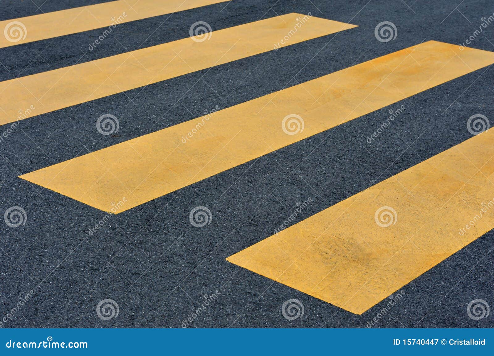 yellow pedestrian crossing on black pavement