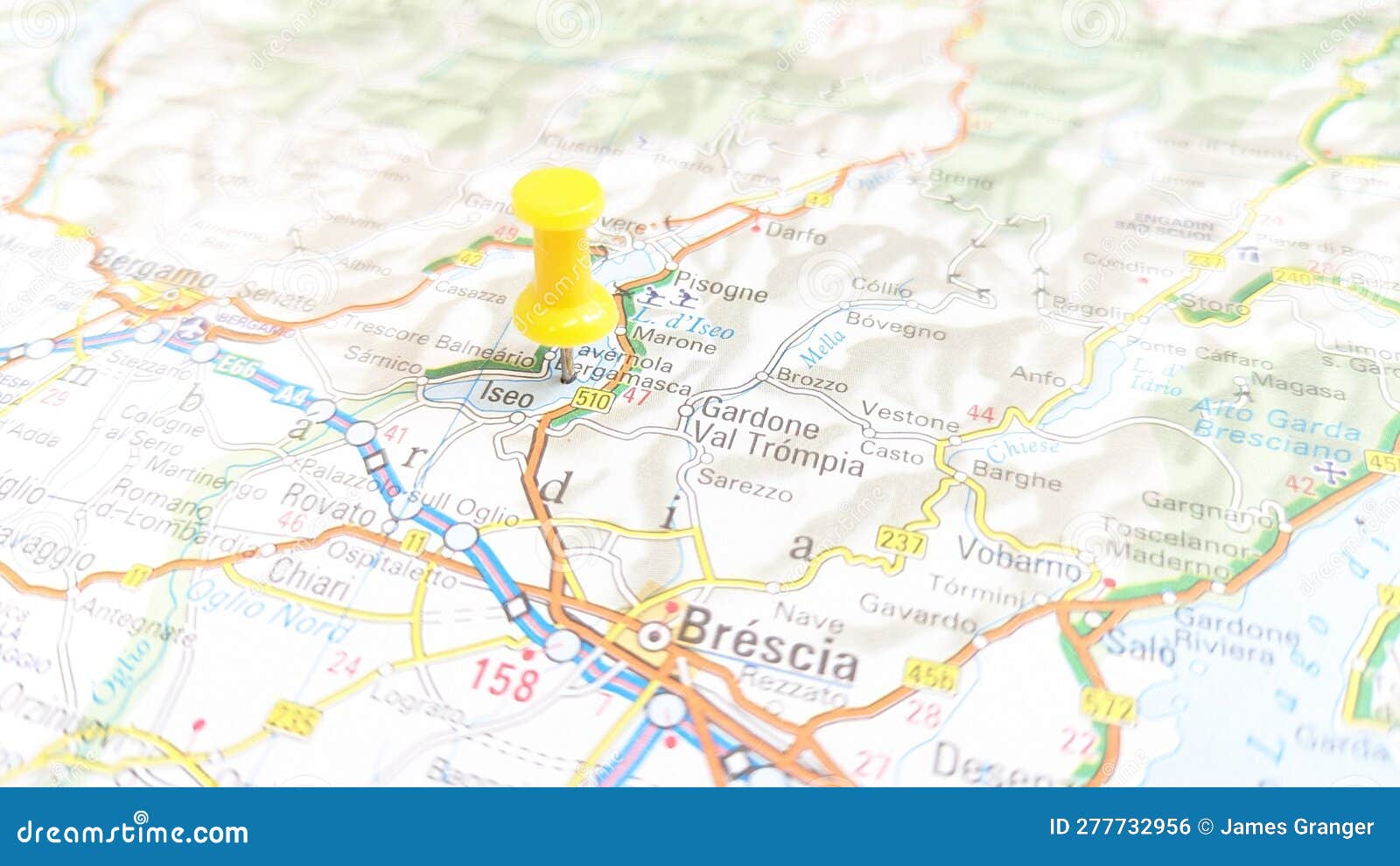 a yellow pin stuck in lake iseo on a map of italy