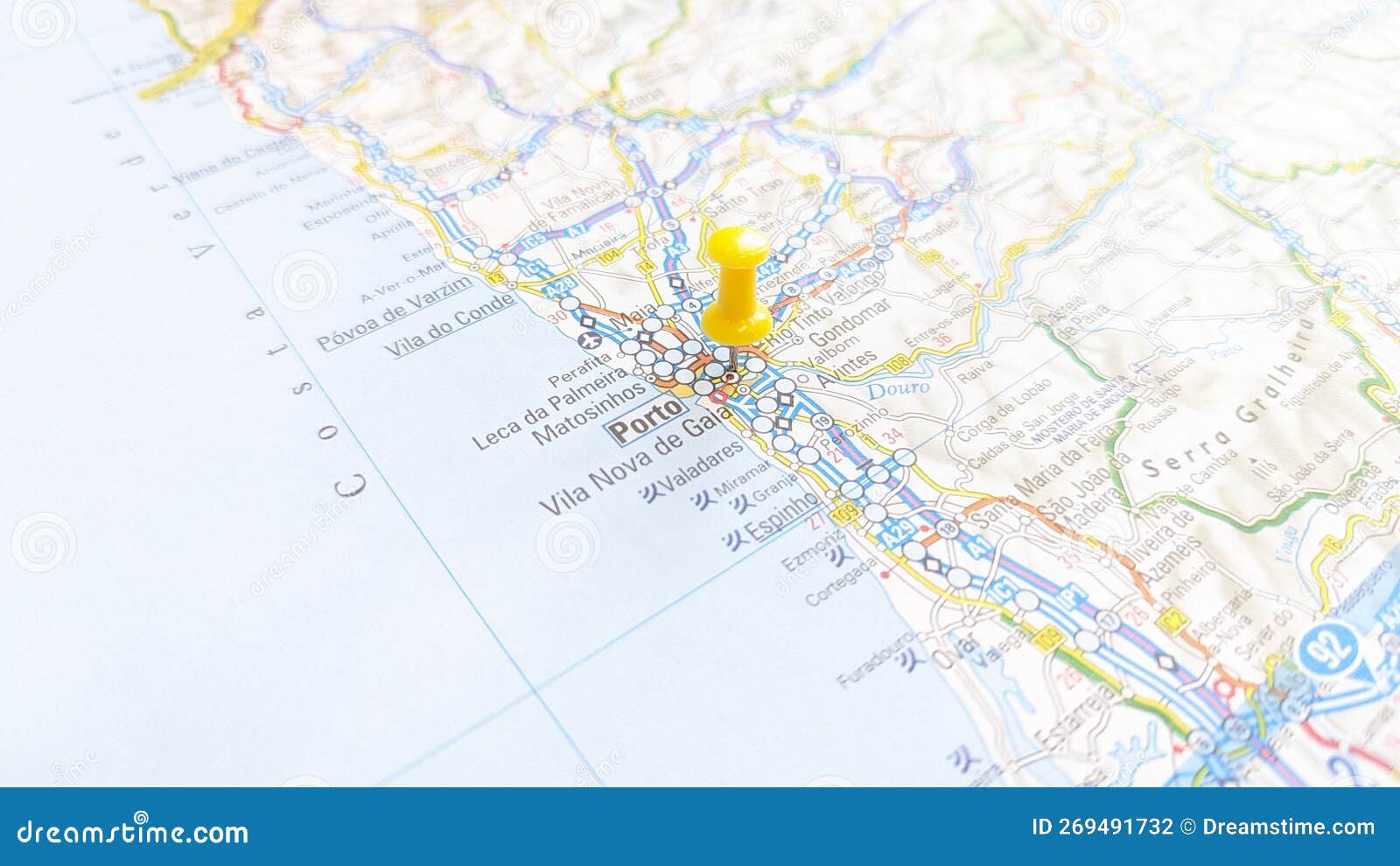 a yellow pin stuck in porto on a map of portugal