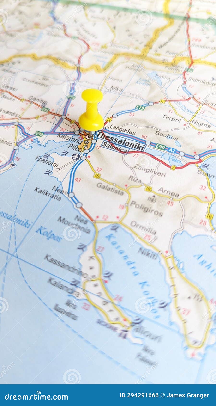 a yellow pin stuck in thessaloniki on a map of greece portrait